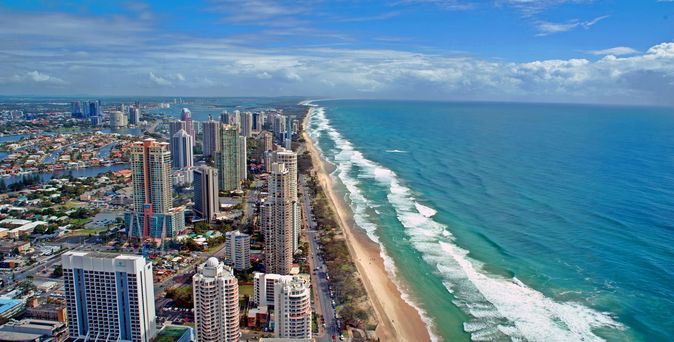 Blick von oben auf Goldcoast mit Skyline von Hochhäusern und Strand und Meer 